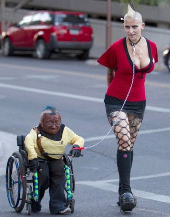 mujer enana en silla de ruedas con punki encadenada WTF