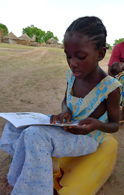 Aissata reading Tostan's children's books