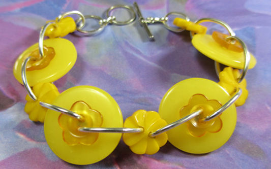 Rhapsody Flower Bracelet Yellow bracelet has cute big buttons and flower linked together
