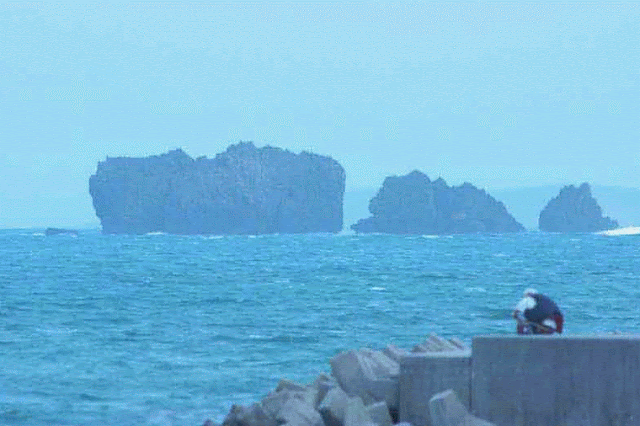 ocean, seawall, woman fishing, rocks