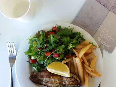 Plate of grilled fish, salad and chips.