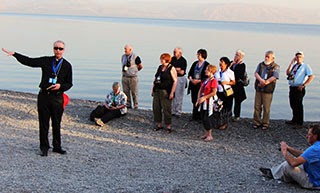 Pilgrims on the edge of Sea of Galilee at Tabgha Pilgrims on the edge of Sea of Galilee at Tabgha