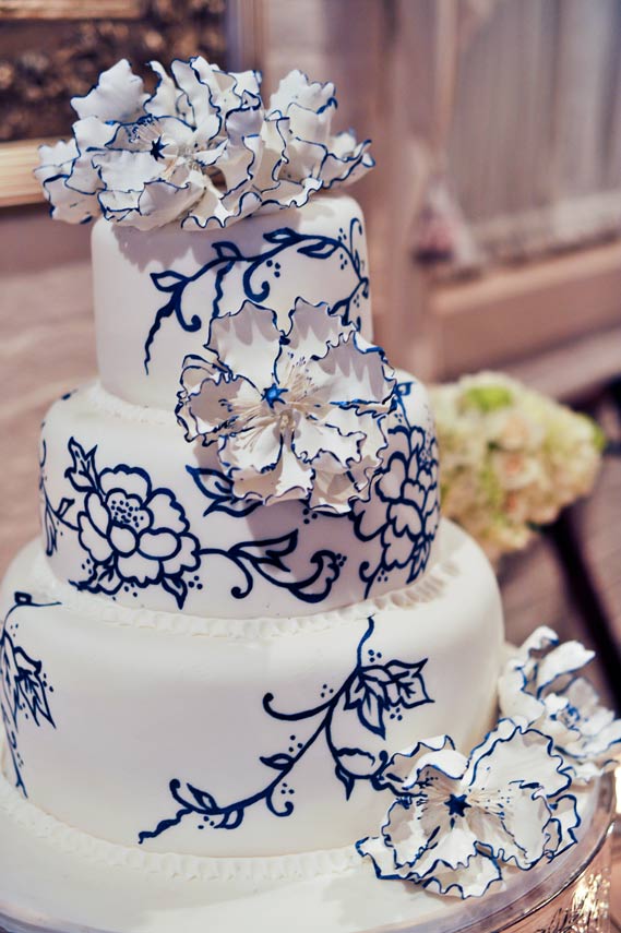 Exquisite wedding cake with hand painted flowers in dark blue
