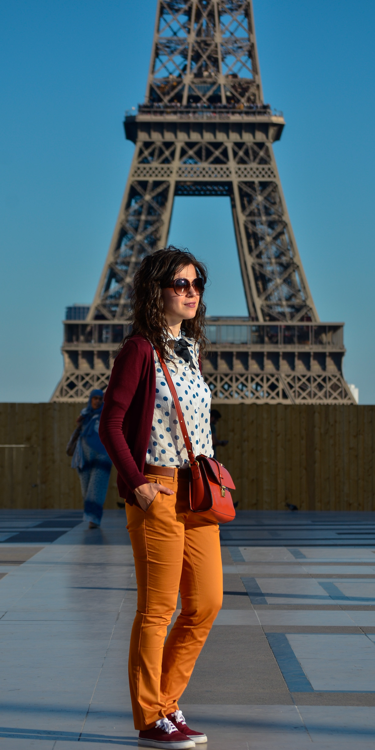 preppy fall outfit in Paris mustard pants burgundy sweater sneakers H&M orange satchel bag dotted shirt blue dots black bow tie champs elysees jardin de tuileries eiffel tower