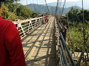 Crossing the wooden bridge on my way to Pha Thao caves.