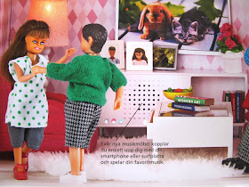 Modern dolls' house scene of two dolls dancing in front of a stereo.