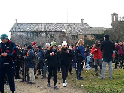 La parada del cafè amb la façana nord de Can Bertran i el campanar de Sant Jaume del Pont de Cabrianes al fons La parada del cafè amb la façana nord de Can Bertran i el campanar de Sant Jaume del Pont de Cabrianes al fons