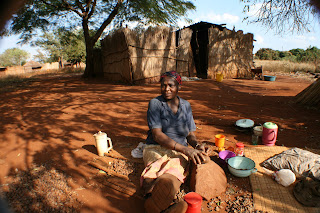 Gogo cracking marula using the traditional "big-rock/little rock" technique Gogo cracking marula using the traditional "big-rock/little rock" technique