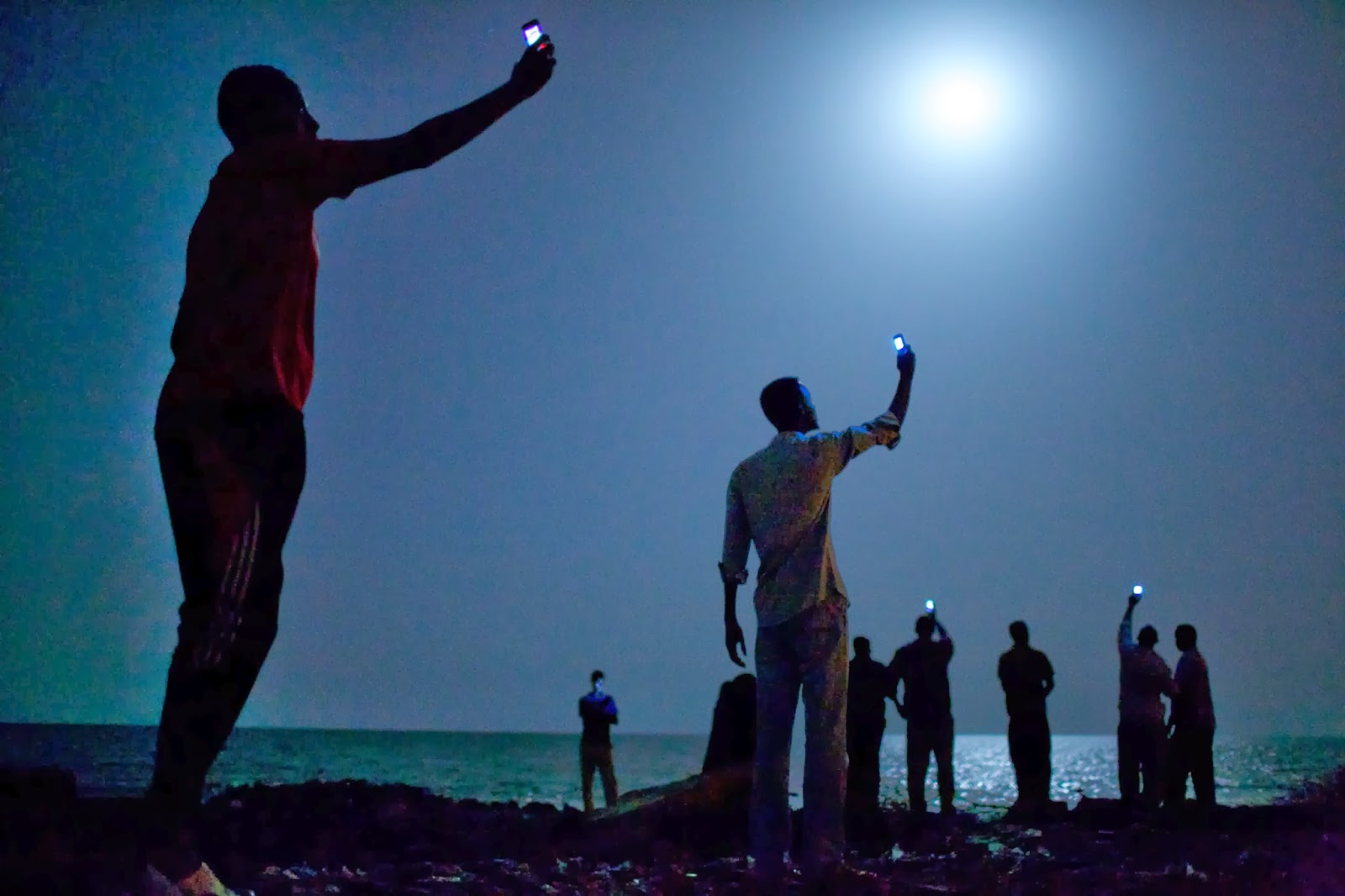 World Press Photo of the Year 2013 John Stanmeyer, USA, VII for National Geographic 26 February 2013, Djibouti City, Djibouti African migrants on the shore of Djibouti city at night, raising their phones in an attempt to capture an inexpensive signal from neighboring Somalia—a tenuous link to relatives abroad. Djibouti is a common stop-off point for migrants in transit from such countries as Somalia, Ethiopia and Eritrea, seeking a better life in Europe and the Middle East. World Press Photo
