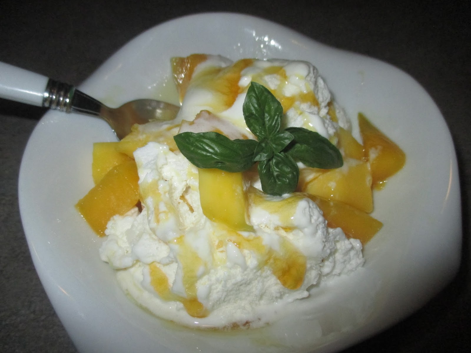 VANILLA ICE CREAM WITH MANGO AND BASIL LEAVES Gelato alla vaniglia con mango e foglie di