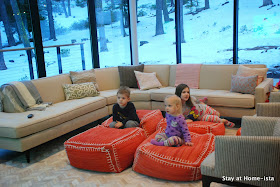 Kids watching TV on poufs in the living room