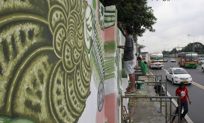 Filipino artists paint a mural on a wall in EDSA, a main highway, with air-purifying paint in Metro Manila February 1, 2012.