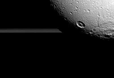 Диона на фоне колец Сатурна