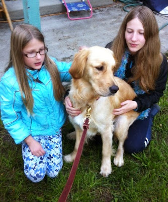 Sarah and her sister pose with Ella (Golden Retriever) in their yard on the grass. Sarah and her sister pose with Ella (Golden Retriever) in their yard on the grass.