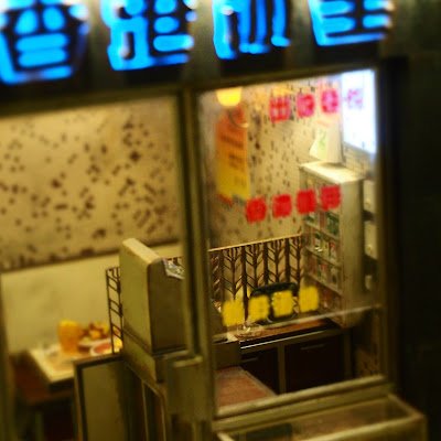 Exterior of a miniature Hong Kong cafe at night.
