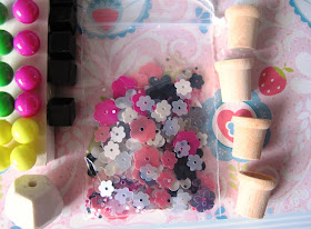 A set of coloured round push pins, a bag of daisy sequins, and four wooden dolls' house plant pots.