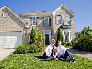 Parents with their young daughter seated outside their home Parents with their young daughter seated outside their home