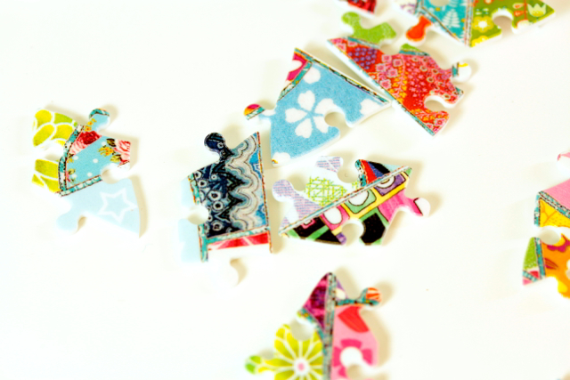Mädchen puzzlet den Eiffelturm von Ravensburger in der Tula Moon Edition Bunte Puzzleteile im Patchwork-Look