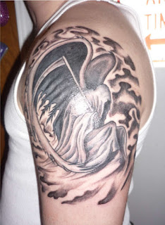 tattoo covering the shoulder and the upper arm: Angel of Death / Grim Reaper depicted with archangel-like feathered wings