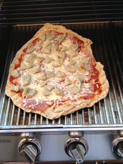 A Pizza cooking on the grill