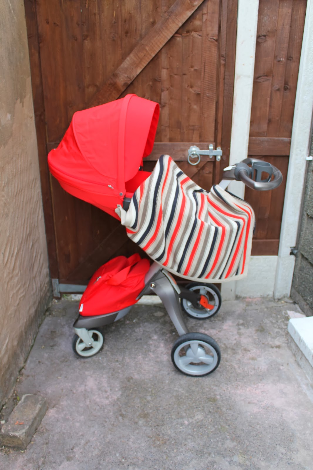 Red textiles on the Stokke Xplory Matching stripe blanket for the red Stokke Xplory Textiles