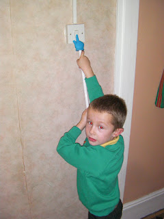 using a rubber hand on a stick to operate a light switch