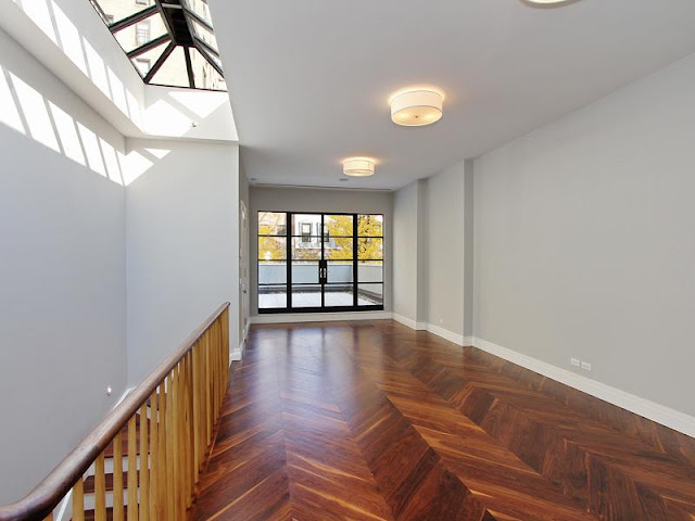 Sun room with herringbone wood floor, skylight and black French doors exiting to a patio