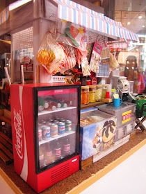 Corner of a modern dolls' house miniature Hong Kong Joyful Store, showing a drink fridge and an ice cream freezer.