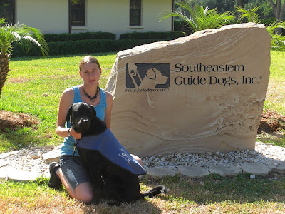 Picture of Rudy & I beside the guide dog sign - he's in coat