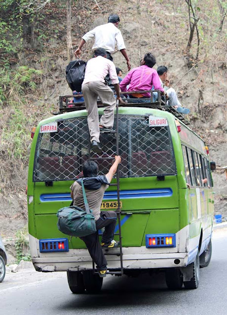 people climbing atop a bus when it is moving