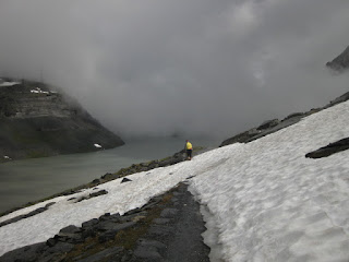 Cyclist traversing snowfield along the Gemmipass, Switzerland