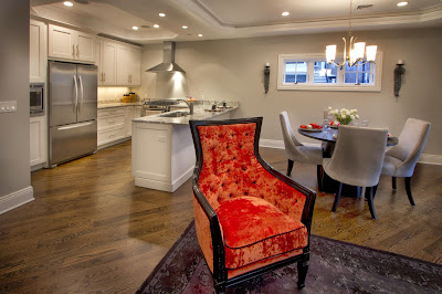 closer look to the orange chair and dining-kitchen area behind it closer look to the orange chair over the lounge area