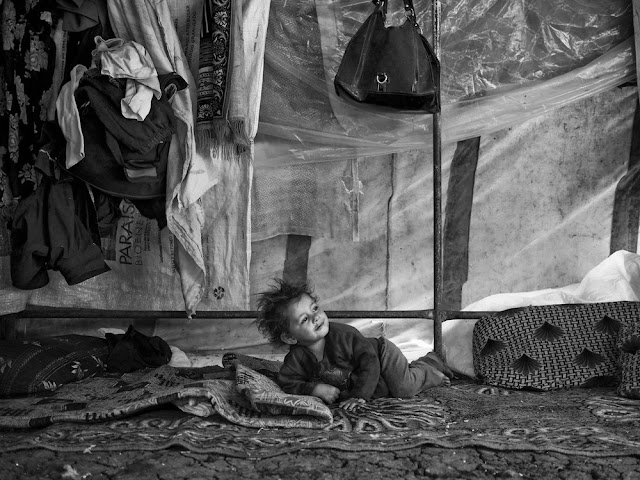 Um menino Sírio acorda dentro da tenda da família no Vale de Bekaa, Líbano. Com o aumento da população dos campos, provisões básicas não são suficientes. Um menino Sírio acorda dentro da tenda da família no Vale de Bekaa, Líbano. Com o aumento da população dos campos, provisões básicas não são suficientes.