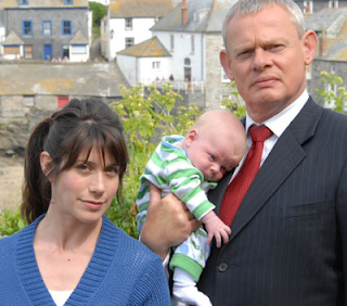 Neither of the actors seems very comfortable holding a baby