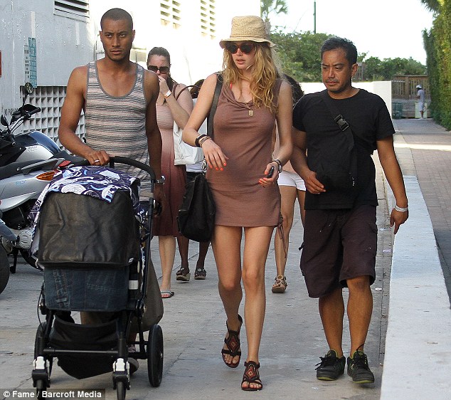 Victoria's Secret model Doutzen Kroes leaves her husband holding the baby as