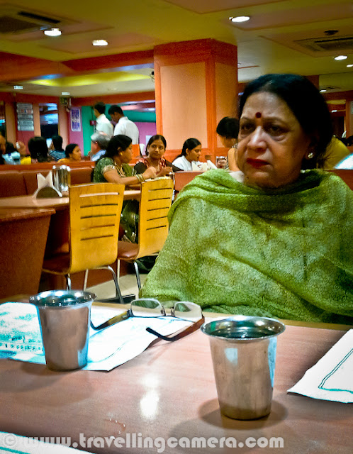 Few days back one of my friend told me about Sarvana Bhavan in Connaught place and we though of having lunch at the same place. It's just opposite to Janpath Market near CP, Delhi. Let's have a quick Photo Journey to Sarvana Bhavan in Connaught Place with some information about it's food and specialties...Welcome to Sarvana Bhavan. As you know, all popular places in Delhi are usually crowded. So the story of our lunch also started with waiting time for 25 minutes. And after a long wait we had to share the table. Since my friend was crazy about the South Indian food here, I simply followed the trends if Sarvana Bhavan. Otherwise I would have spent those 25 mins in locating some other good place which could offer comfortable seating at least.Here is what exactly we saw inside Sarvana Bhavan. Both of the floors were full of people and seating were extremely tight. There was hardly any space between the tables. It seemed that they get lot of customers daily and available real-estate need to be utilized in such a way.Place is fine for young and old age folks, but if someone want to visit the place with children, I would want to warn them. Waiting for 20 minutes at least and then getting into a tight space and get out of the space after finishing your food - This whole cycle will suffocate the kids with you. As there is no place for them to enjoy inside Sarvana Bhavan.Anyway, it was time to look at the menu and decide on items we wanted to have for Lunch. I got the reasoning behind the popularity and spacing problem. Their charges were very nominal. But I was expecting lovely south Indian food at same time. Let's see how it goes...We were sharing our table with this interesting couple, who ordered very unique items in lunch. They took enough time to look at all the items in Menu and then decided to have a special thali and Paper masala Dosa, with salted Dahi-Vada after main meal.Overall place was clean and comfortable, if we forget about the spacing. It's a completely air conditioned restaurant, which serve almost every South Indian Dish. Service was again good, as one person was dedicated for each row, who was only involved for taking order and making sure that no one is waiting for any type of service. Most of them communicate in South Indian Language(s)...We ordered on simple Thali and a Butter Rava Masala Dosa. I failed to notice anything good about the food here. South Indian at Sagar Ratna is far better that Sarvana Bhavan, but not sure why it's name is so popular. If you are reading this post and like Sarvana Bhavan food, please comment back and share about the things you like at this place.When we were waiting for our order to come, uncle and aunti were discussing about Sarvana Bhavan in Lajpat Nagar and they were really impressed by the food there. At the same time uncle received 4-5 calls and informed everyone that he is in CP Sarvana Bhavan with his wife.Here come our simple thali with a  two Masala Dosas, Sambhar, Coconut chutney, one Subzi & some rasam. And yes, Sweet halva was also part of this thali. Food was ok, but not something great or special... Give an option, I will never com back to this place and would love to go to Sagar ratna for real taste of South Indian Food.After having food expressions were really like this. Uncle was really disappointed with food and also gave the same feedback to manager on second floor. Although, Manager's expressions were saying that he was not bothered much about what the gentleman explained to him.Sarvana Bhavan is good for one time experience and then decide yourself :)