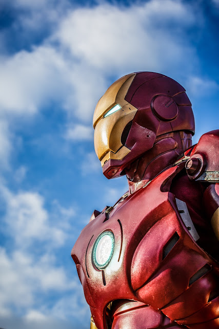 Iron Man, against a blue sky with clouds