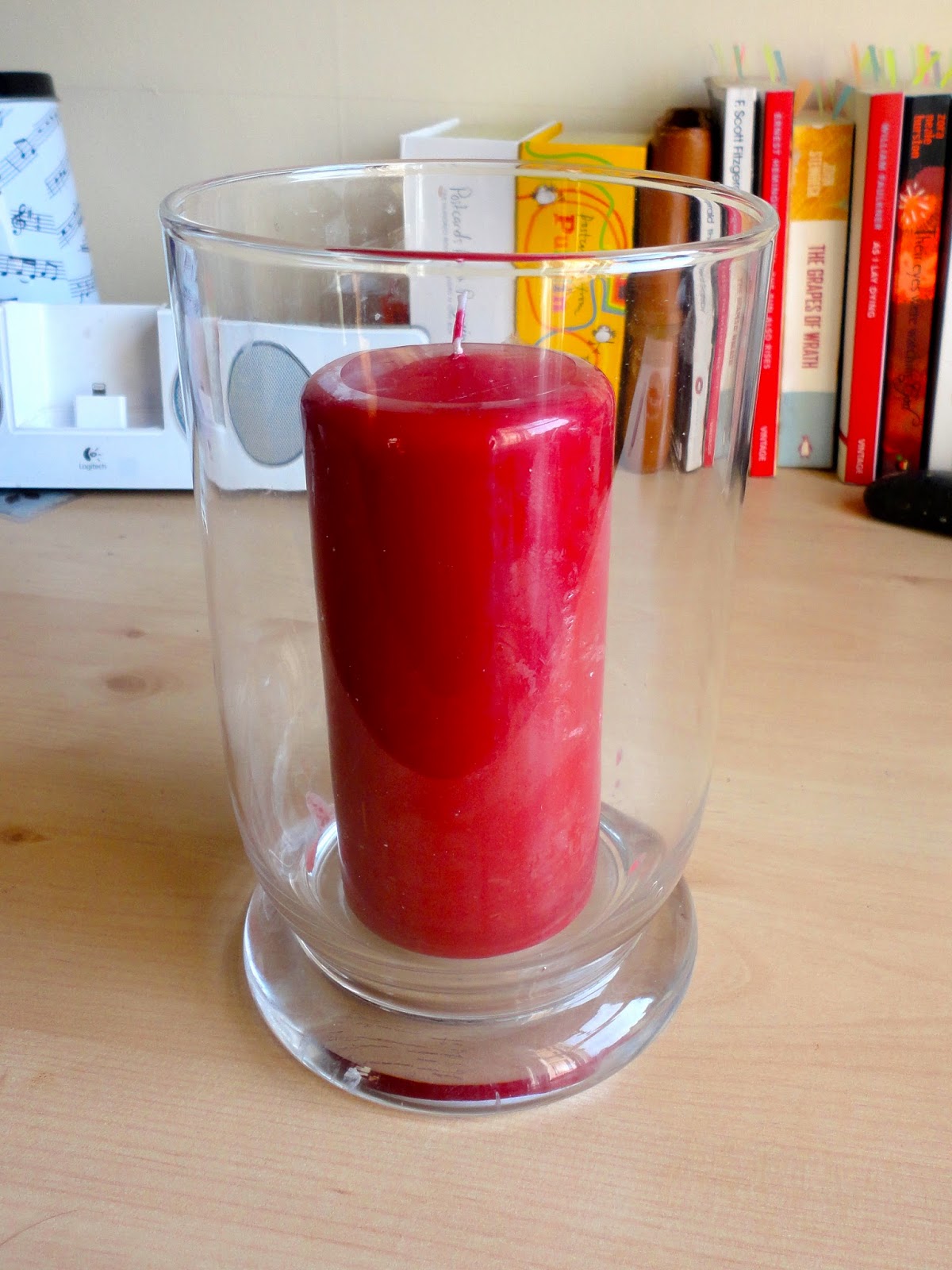 Red pillar scented candle in glass hurricane jar