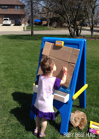 girl drawing outdoors on a fisher price easel
