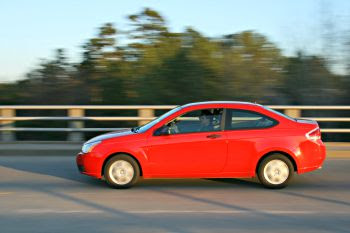 Un coche rojo circula por la carretera (WIKIMEDIA)