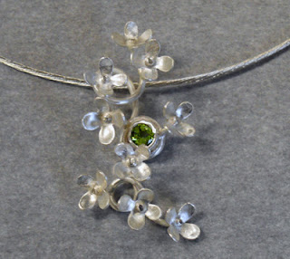 Tiny hydrangea cluster pendant with peridot gemstone.