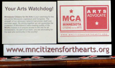 Display for Minnesota Citizens for the Arts with web address sign reading mncitizensforthearts.org