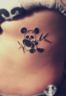 side tattoo featuring a panda eating bamboo