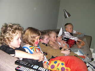 kids lined up on sofa to watch tv