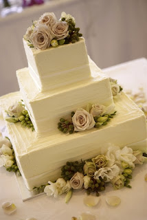 A traditional wedding cake with square tiers and interesting texture.