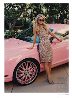 Paris Hilton in leopard print outfit and sunglasse standing by her pink car