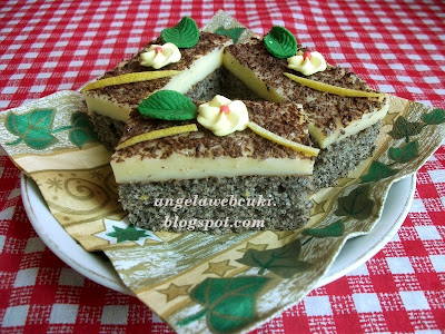 Citrompudingos bögrés mákos sütemény, reszelt csokoládéval megszórva a teteje, díszítésként virág és levél marcipán.