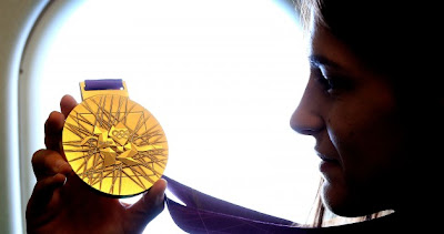 Katie Taylor examines her Olympic gold medal on her way home to Bray