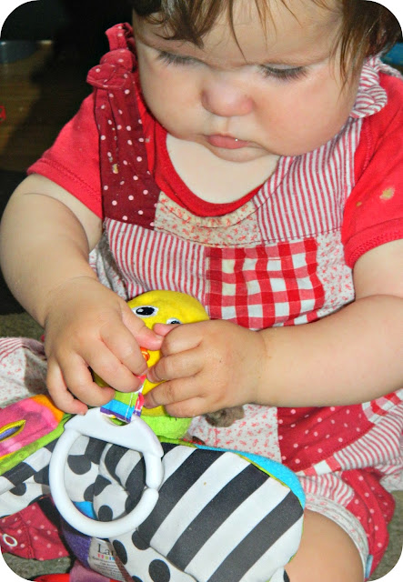 Baby girl  playing with Freddie the Firefly TOMY Lamaze
