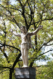 Statue of crucified Jesus against the branches of a tree